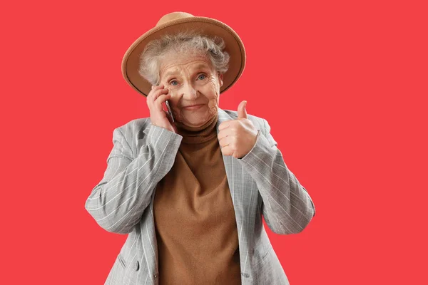 Senior Vrouw Praten Door Mobiele Telefoon Rode Achtergrond — Stockfoto
