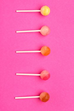 Pembe bir arka plan üzerinde tatlı lolipop