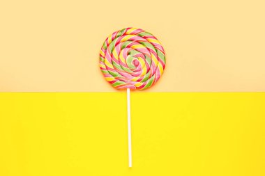 Sarı ve bej arkaplanda renkli lolipop