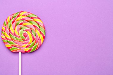 Mor arka plan üzerinde renkli lolipop