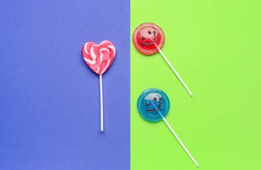 Tatlı lolipoplar mavi ve yeşil arka planda