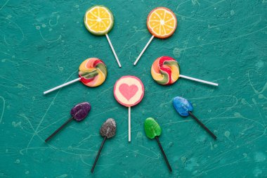 Yeşil grunge masasında farklı lolipoplarla kompozisyon