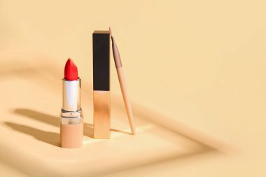 Renkli arkaplanda güzel ruj ve makyaj fırçası