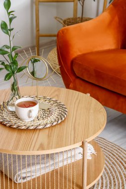 Oturma odasının içinde çay, vazo ve ayna olan kahve masası.