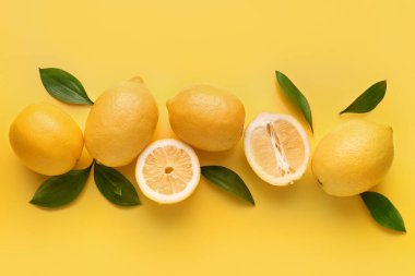 Composition with fresh lemons on yellow background