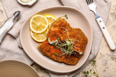 Lezzetli kızarmış morina balığı ve arkaplanda limon.