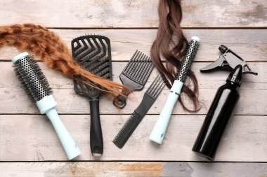 Fırçalı kıvırcık kızıl saçlar ve hafif ahşap arka planda sprey.