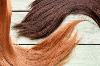 Kahverengi ve kızıl saçlar yeşil ahşap arka planda