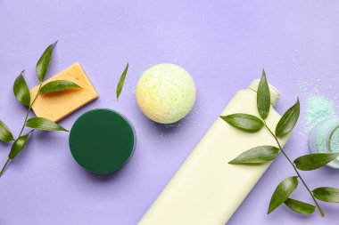 Aksesuarlı banyo bombası ve leylak arka planda dallar