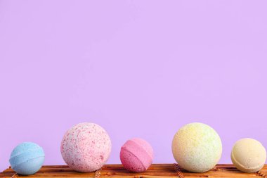 Leylak arka planında banyo bombaları olan bambu paspas.