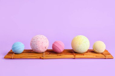 Leylak arka planında banyo bombaları olan bambu paspas.