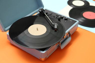 Renk arkaplanında vinil diskleri olan kayıt oynatıcı, kapat