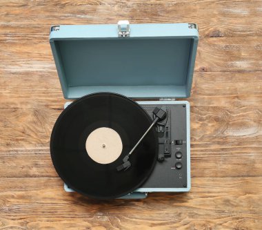 Ahşap arkaplanda vinil diski olan kayıt çalar