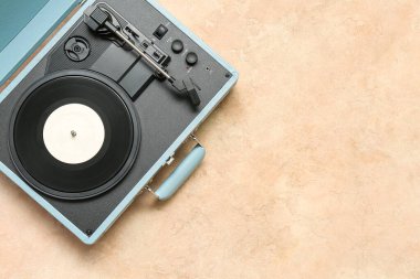 Bej arka planda vinil diski olan kayıt oynatıcı