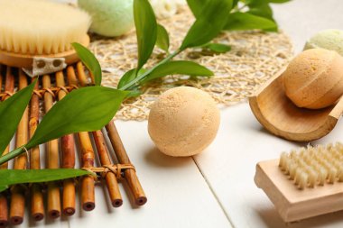 Banyo bombaları beyaz ahşap masa üzerinde bitki dalları, yakın plan