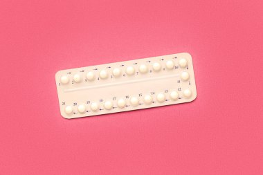 Pembe arka planda hormonal haplar.