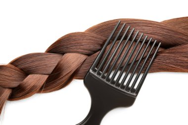 Beyaz arka planda fırçayla örülmüş kahverengi saçlar, yakın plan.