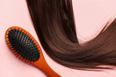 Kahverengi saçlı pembe arka planda fırça