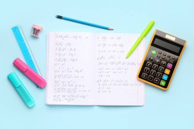 Matematik formülleri, hesap makinesi ve mavi arkaplan üzerindeki kırtasiye kitapçığı