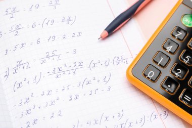 Matematik formülleri, kalem ve hesap makinesi içeren metin defteri, yakın plan