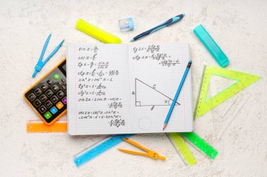 Matematik formülleri, hesap makinesi ve beyaz grunge arkaplanı üzerine kırtasiye defteri