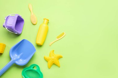 Yeşil arka planda plaj aksesuarları olan bebek için güneş kremi