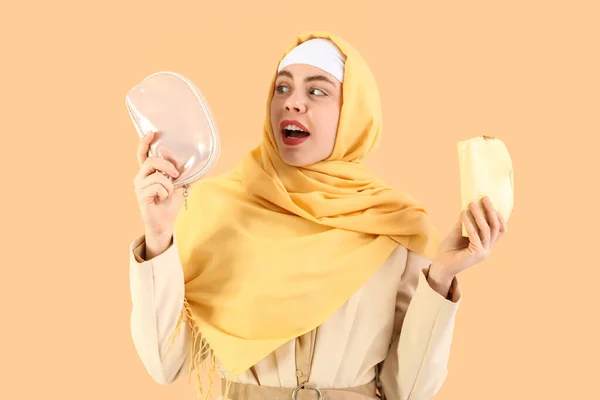 Schöne Muslimin Mit Kosmetiktaschen Auf Beigem Hintergrund — Stockfoto