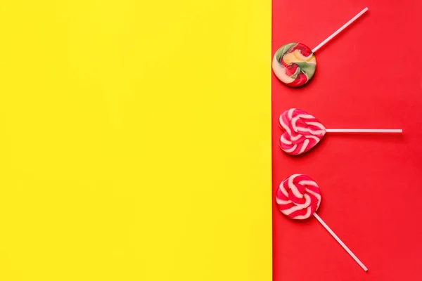 Sweet lollipops on yellow and red background