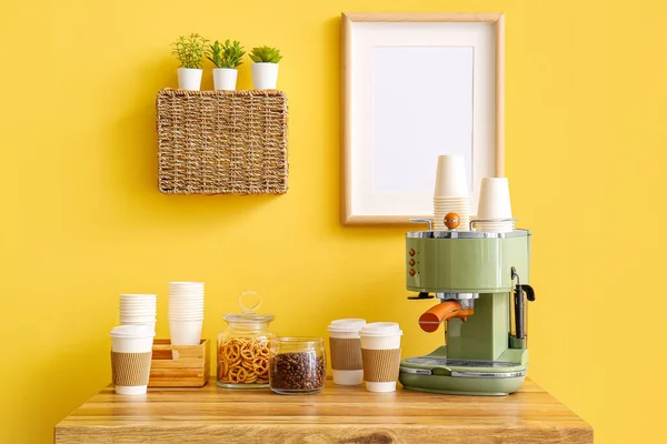 Modern Kahve Makinesi Yemek Fincanları Atıştırmalıklar Sarı Duvarın Yanındaki Masada — Stok fotoğraf