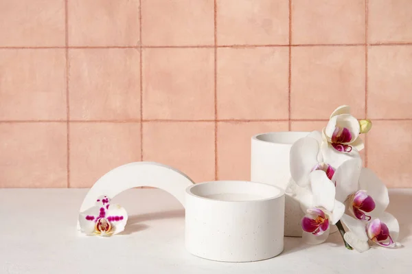 Decorative Plaster Podiums Beautiful Orchid Flowers White Table Tiled Wall — Stock Photo, Image