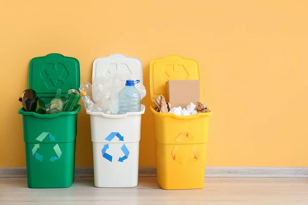 リサイクルシンボルと黄色の壁の近くに別のゴミとゴミ箱 — ストック写真
