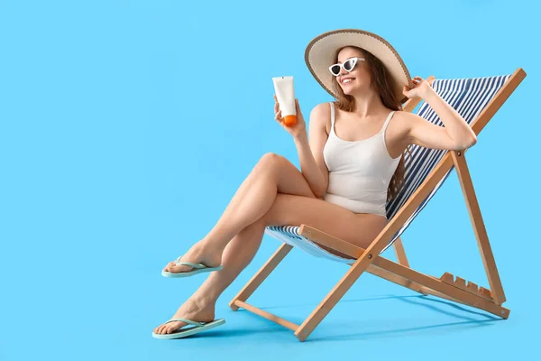 Beautiful Young Woman Sunscreen Cream Sitting Deck Chair Blue Background — Stock Photo, Image