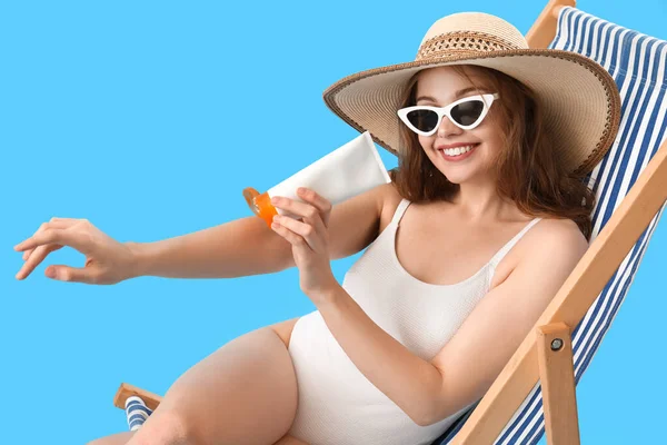 Beautiful Young Woman Applying Sunscreen Cream While Sitting Deck Chair — Stock Photo, Image