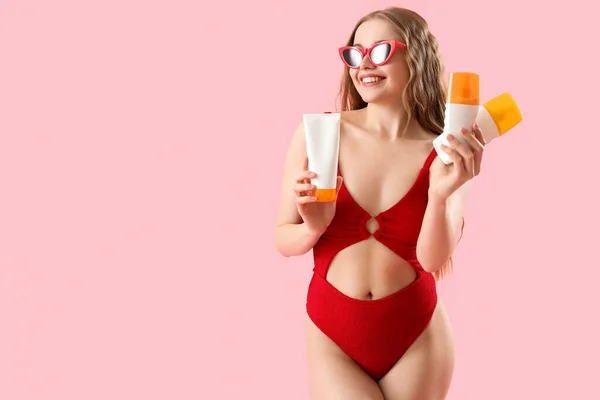 Mooie Jonge Vrouw Met Zonnebrandcrème Crèmes Roze Achtergrond — Stockfoto