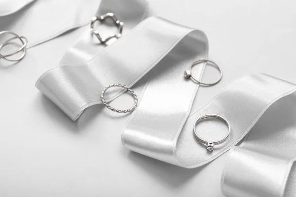Ribbon with silver rings on light background, closeup