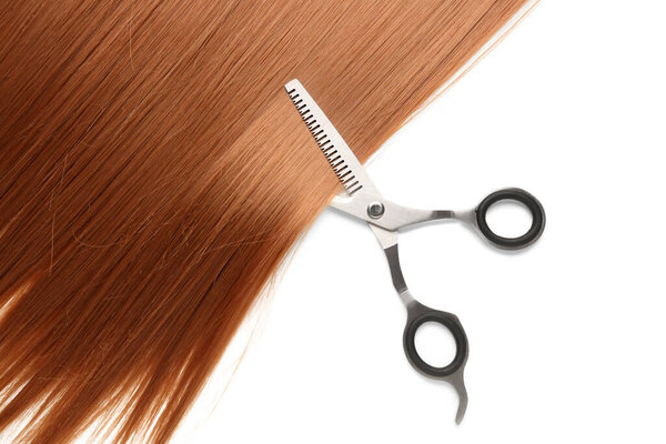 Ginger hair with scissors on white background