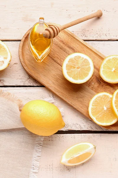 白い木の背景に新鮮なレモンと蜂蜜とボード — ストック写真