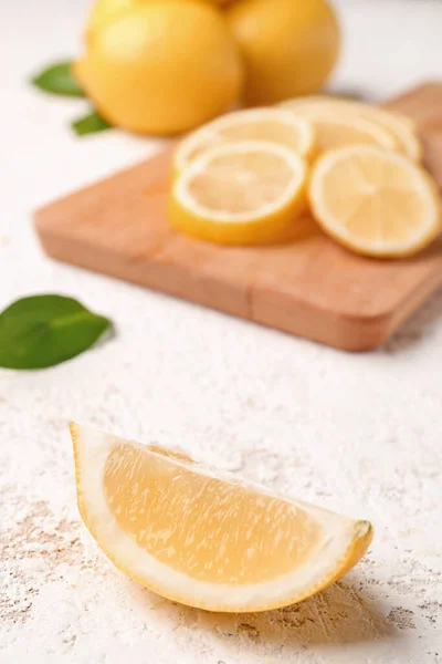Board with fresh lemons on white background