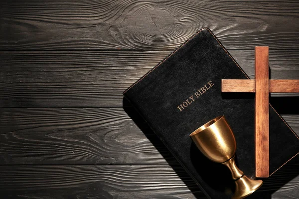 圣经上有十字杯和黑色木制背景的酒杯 — 图库照片