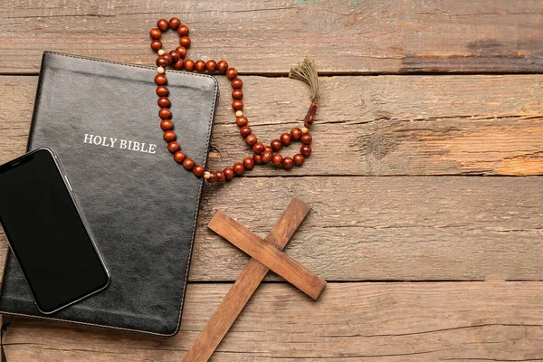 圣经上有手机 祈祷珠子和木制背景的十字架 — 图库照片