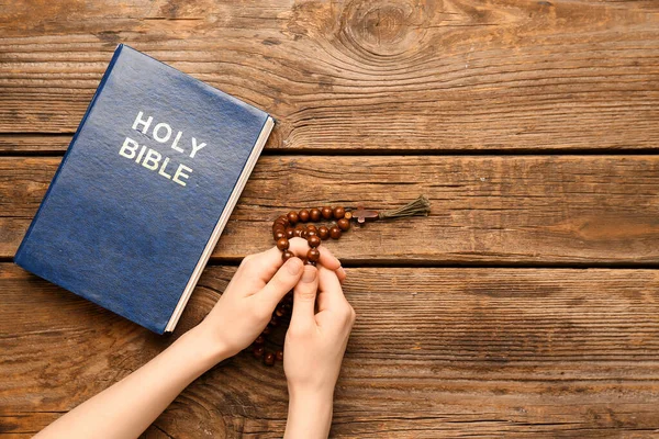 Kvinna Med Bönepärlor Och Bibeln Trä Bakgrund — Stockfoto
