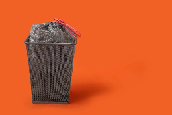 Mülleimer Mit Vollem Müllsack Auf Orangefarbenem Hintergrund — Stockfoto