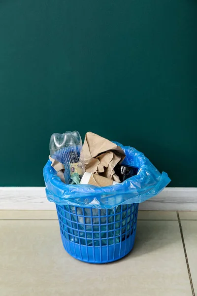 緑の壁の近くに異なるゴミとゴミ箱 — ストック写真