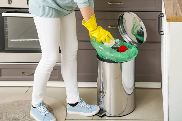 戴橡胶手套的女人把纸杯放进厨房的垃圾桶里 — 图库照片