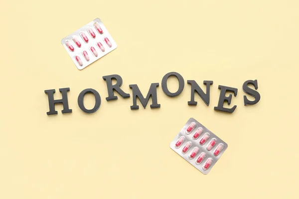 stock image Word HORMONES with pills on yellow background