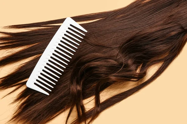 Cheveux Bruns Avec Peigne Sur Fond Beige — Photo