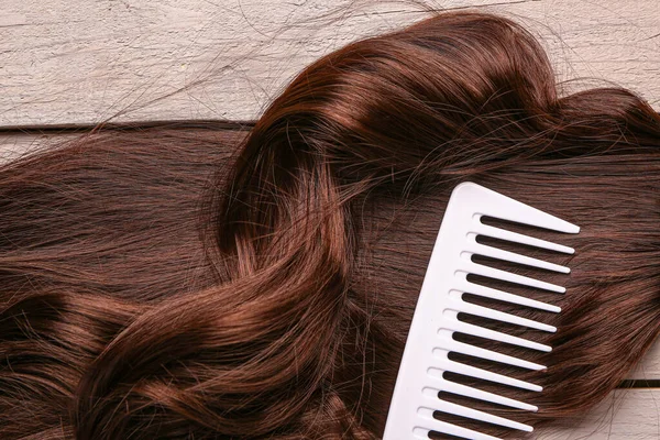 Gri Ahşap Arka Planda Taraklı Kıvırcık Kahverengi Saçlar Yakın Plan — Stok fotoğraf