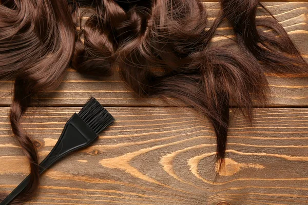 Cheveux Bruns Frisés Avec Brosse Sur Fond Bois — Photo