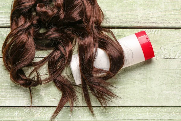 Cheveux Bruns Frisés Avec Bouteille Produit Cosmétique Sur Fond Bois — Photo