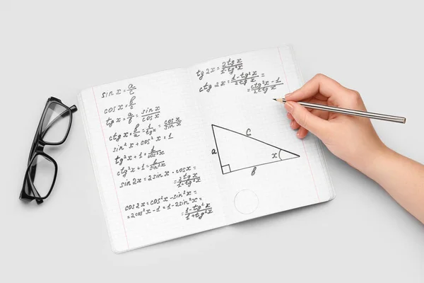 Frau Schreibt Mathematik Formeln Copybook Mit Bleistift Auf Grauem Hintergrund — Stockfoto